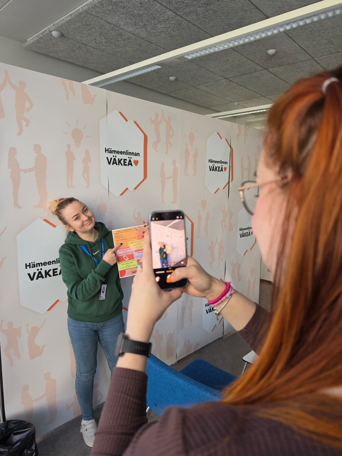 A Youth Services employee taking a photo of a colleague.
